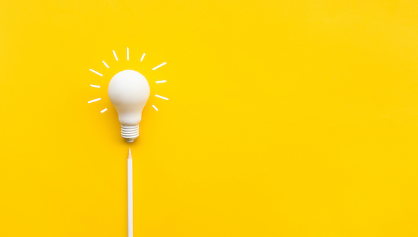 RG4SB_white_idea_lightbulb_with_white_pencil_on_yellow_background